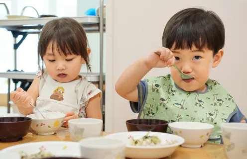 スプーンを使って食事をする園児たち