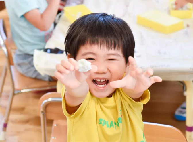できあがった作品を見せる園児