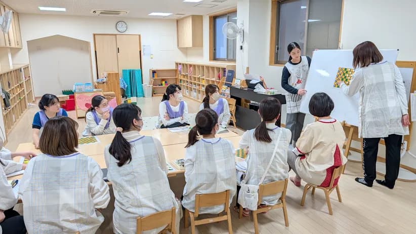 テーブルを囲み、ホワイトボードを使って学び合う職員たち